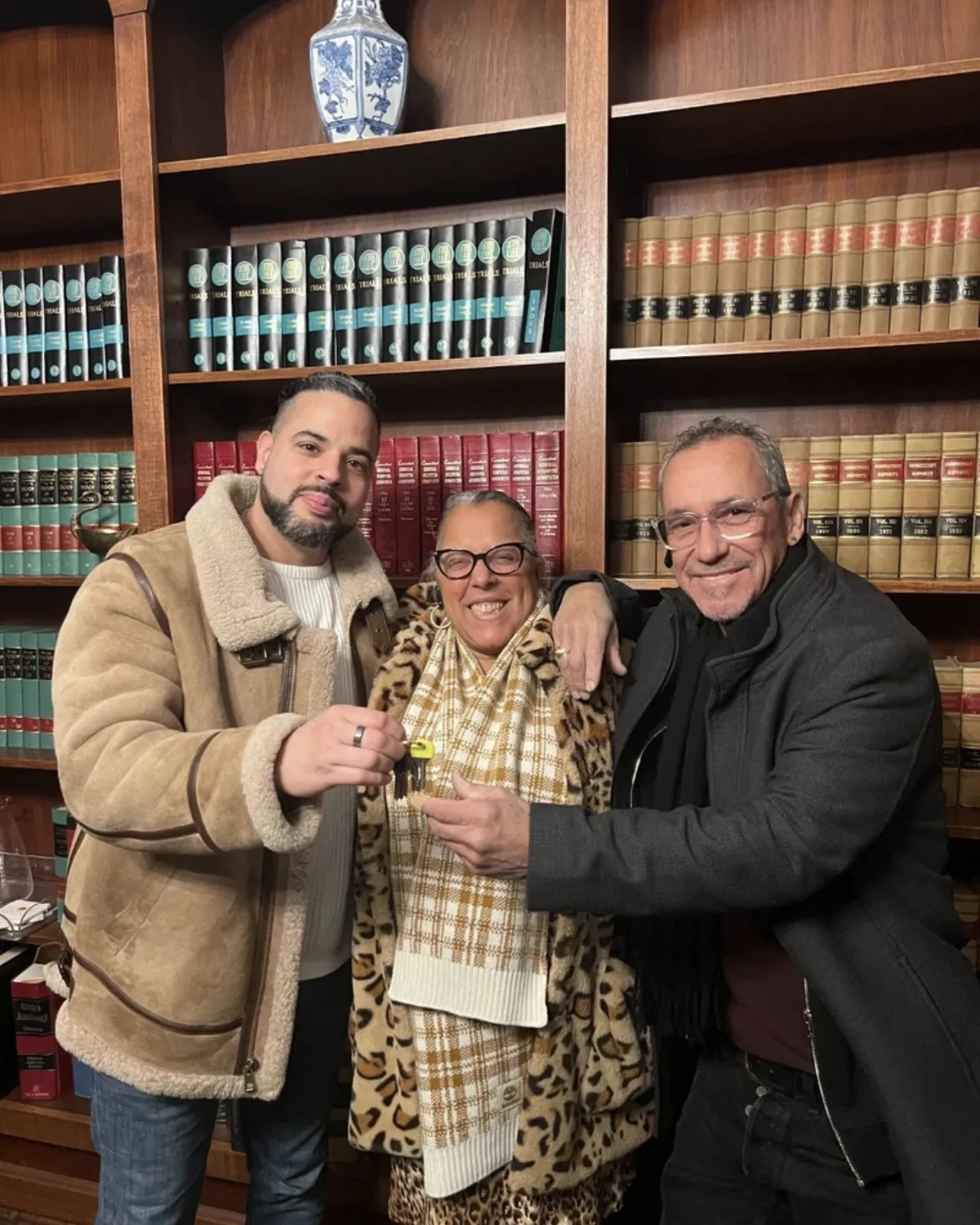 Nicholas handing keys to a client couple at the closing attorney's office.