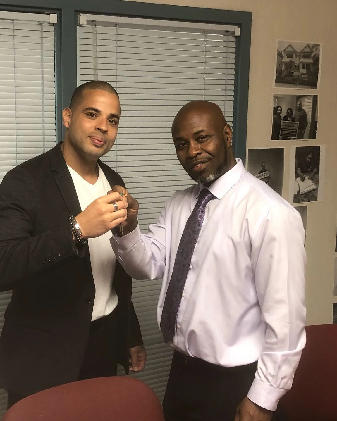 Nicholas handing a set of house keys to a new homeowner.