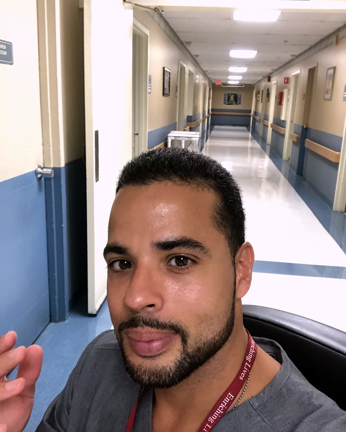 Nicholas on shift in scrubs, in the hallway of the care unit where he worked.