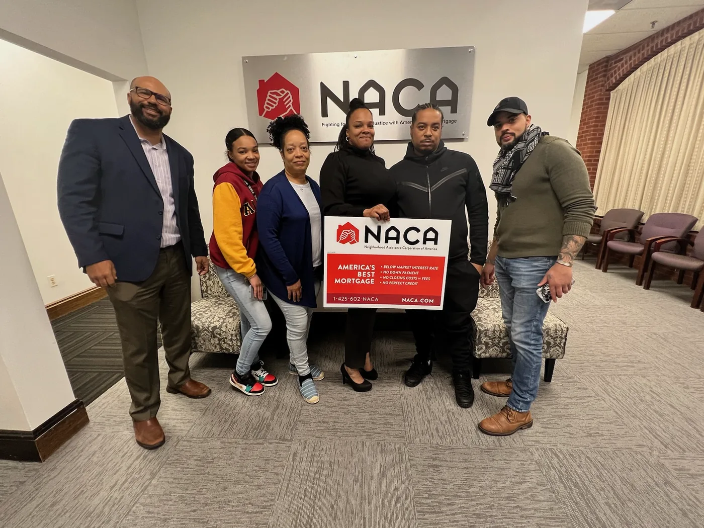 Nicholas with a family and their counselor after the family qualified for a first-time buyer mortgage program.