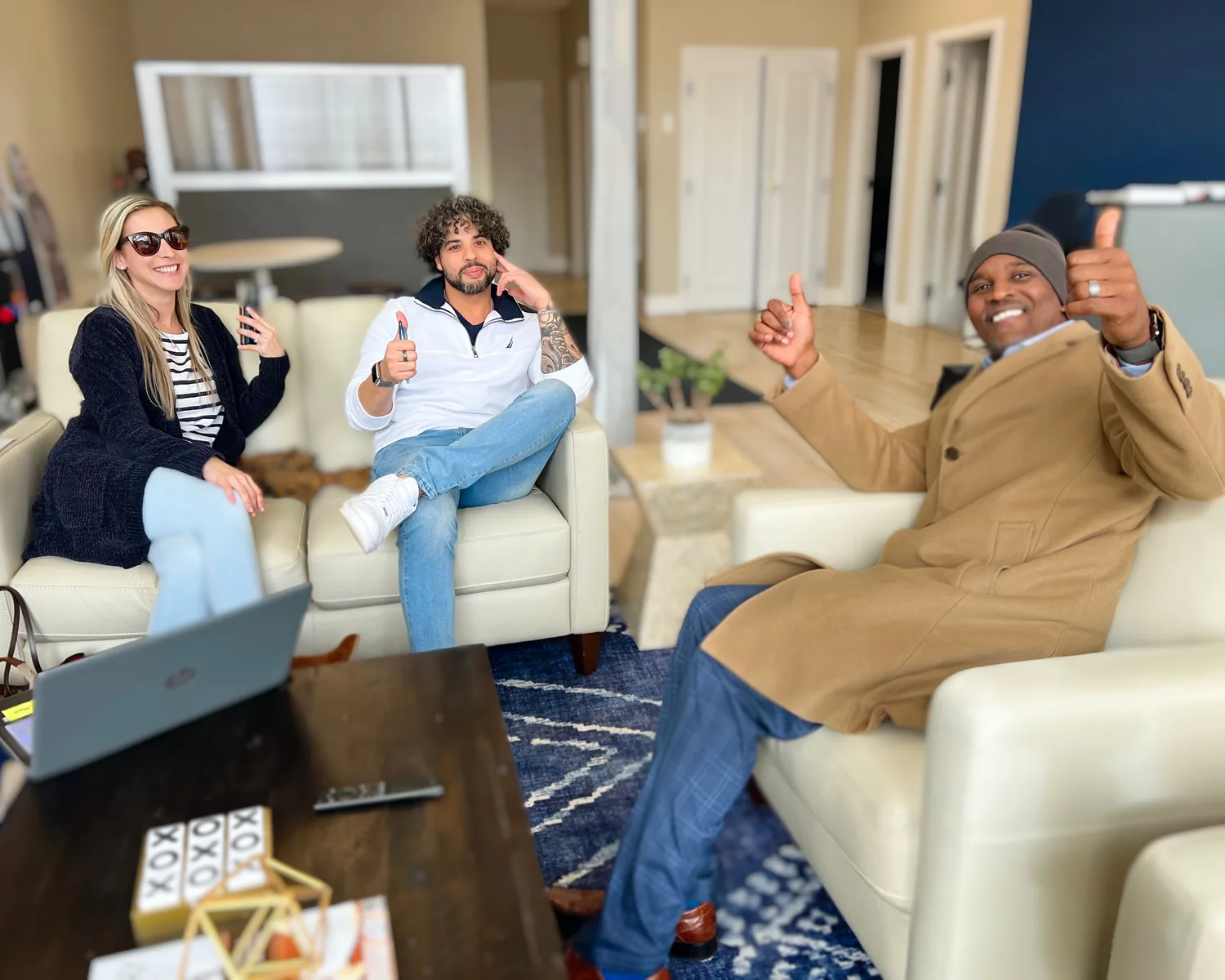 Nicholas with two colleagues on the couches inside the Lewis Real Estate office.
